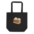 Black tote bag with an open book and stacked books illustration