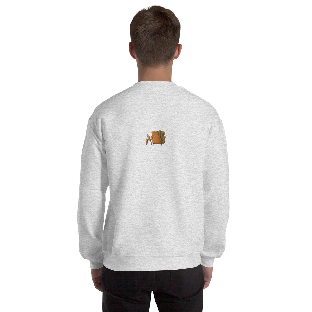 Model wearing Cozy Reading Chair unisex sweatshirt in Ash, back view with small armchair illustration