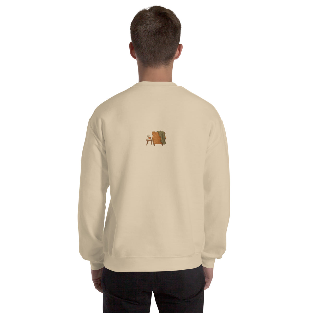 Model wearing Cozy Reading Chair unisex sweatshirt in Sand, back view with small armchair illustration