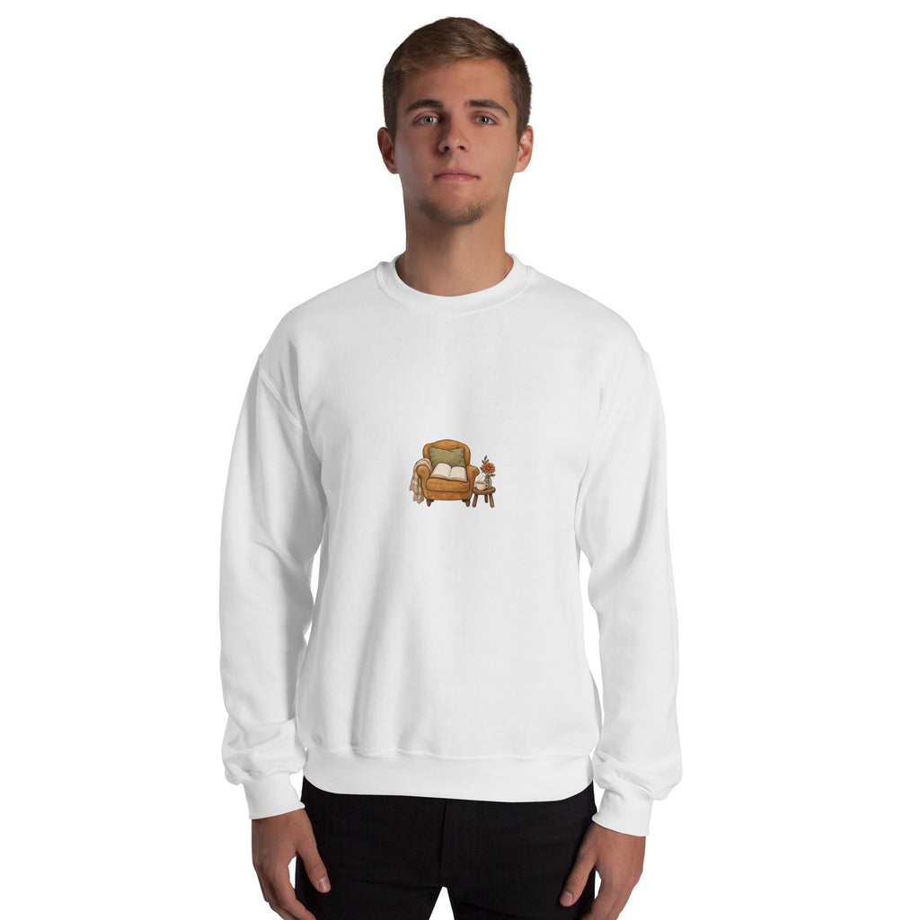 Model wearing Cozy Reading Chair unisex sweatshirt in White, front view with armchair, open book and side table