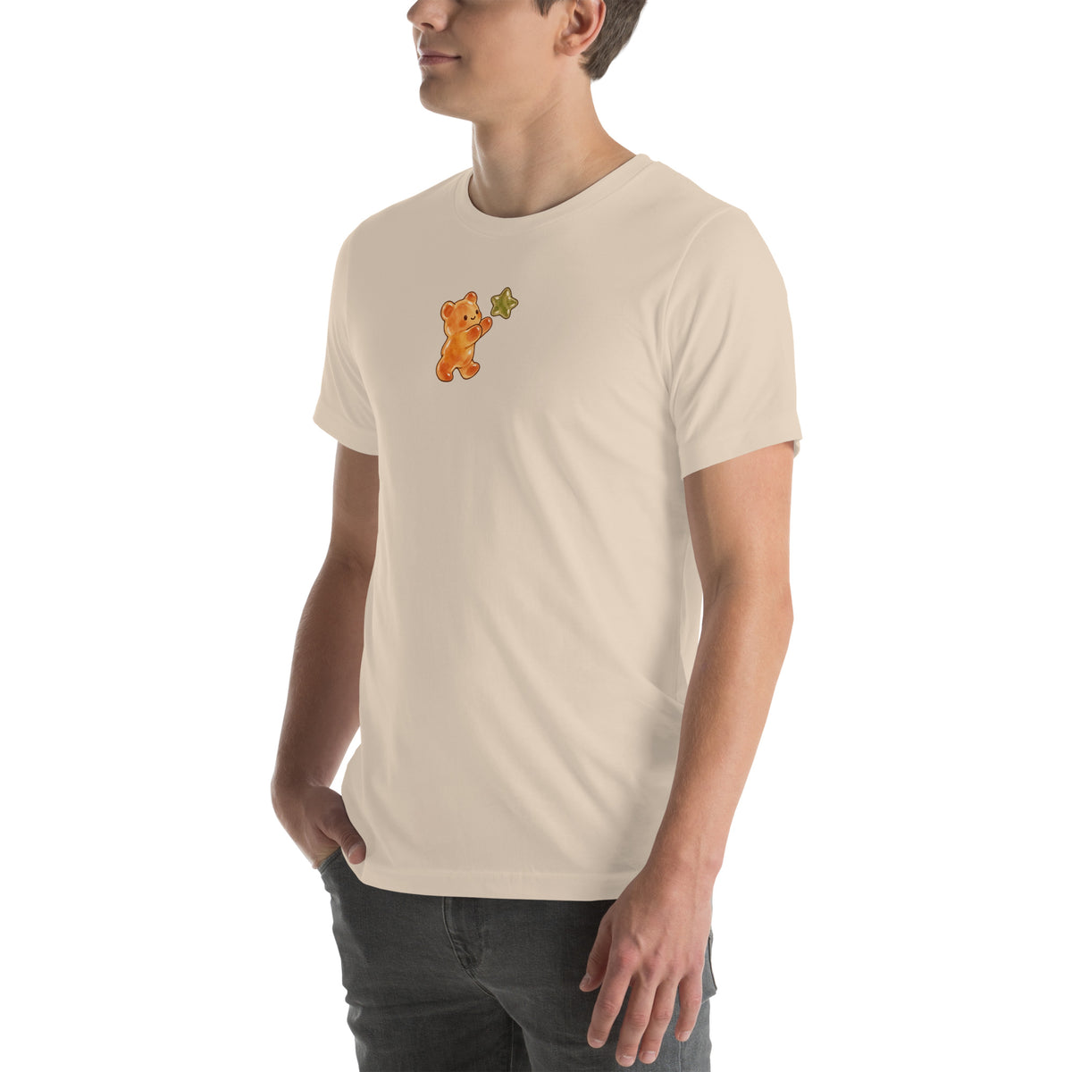 Model wearing Gummy Bear & Star unisex T-shirt in Soft Cream, front view with amber bear reaching for olive star